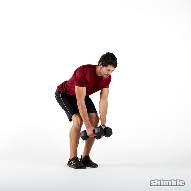 Stand with your feet hip-width apart, knees slightly bent and dumbbells in hand. Keeping your posture, hinge at the waist and let your arms hang forward, palms facing in and elbows slightly bent.